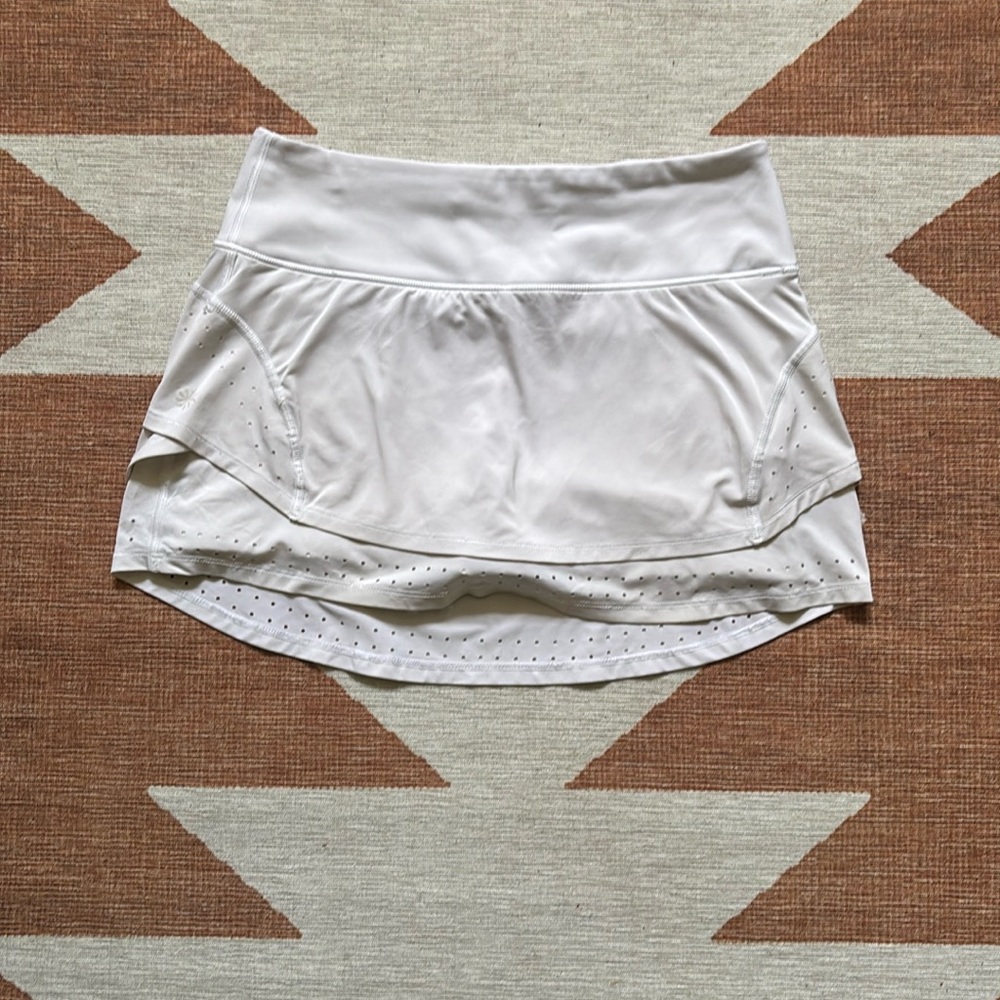 Small white fitted Athleta tennis skirt with perforated layers.